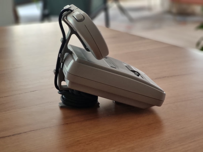 Side view of the SNES Classic Edition display stand, holding the controller upright behind the console