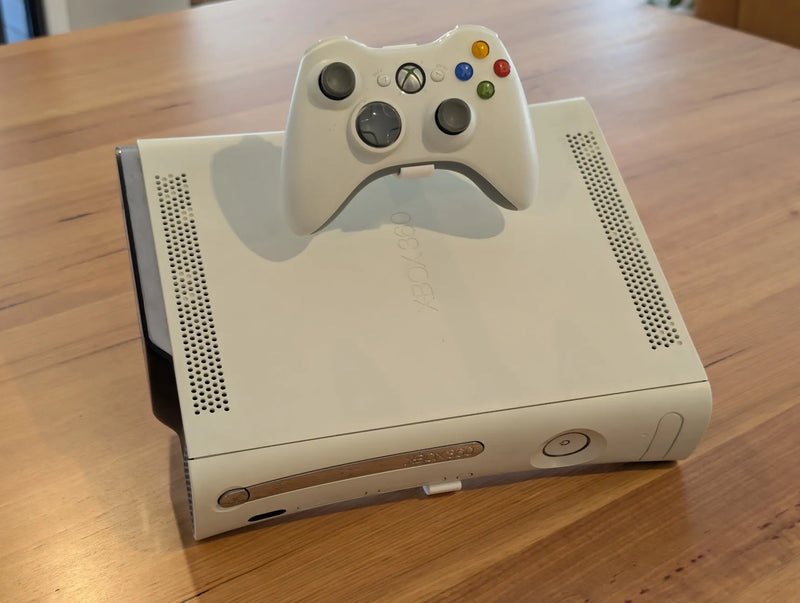 Original Xbox 360 console on the Retro Craft display stand, with a controller held in the built-in holder